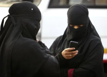 A burqa clad Indian woman checks her phone at a street in Hyderabad, India, Tuesday, March 24, 2015. India's top court affirmed people's right to free speech in cyberspace Tuesday by striking down a provision that had called for imprisoning people who send "offensive" messages by computer or cellphone.The provision, known as Section 66A of the 2008 Information Technology Act, had made sending such messages a crime punishable by up to three years in prison. (AP Photo/Mahesh Kumar A.)